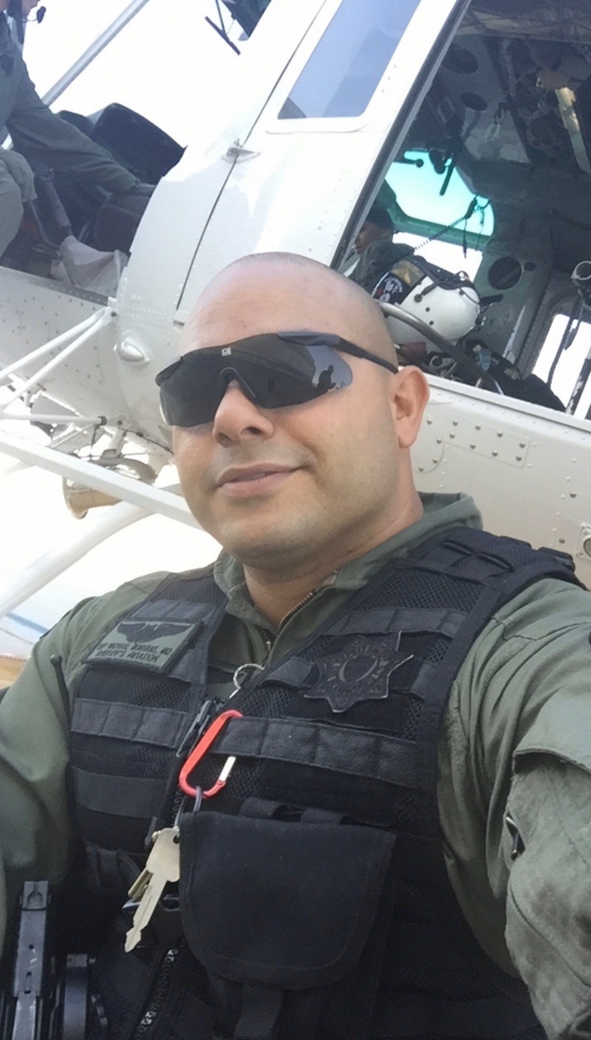 Michael Guirguis, MD in flight gear beside a sheriff air rescue helicopter